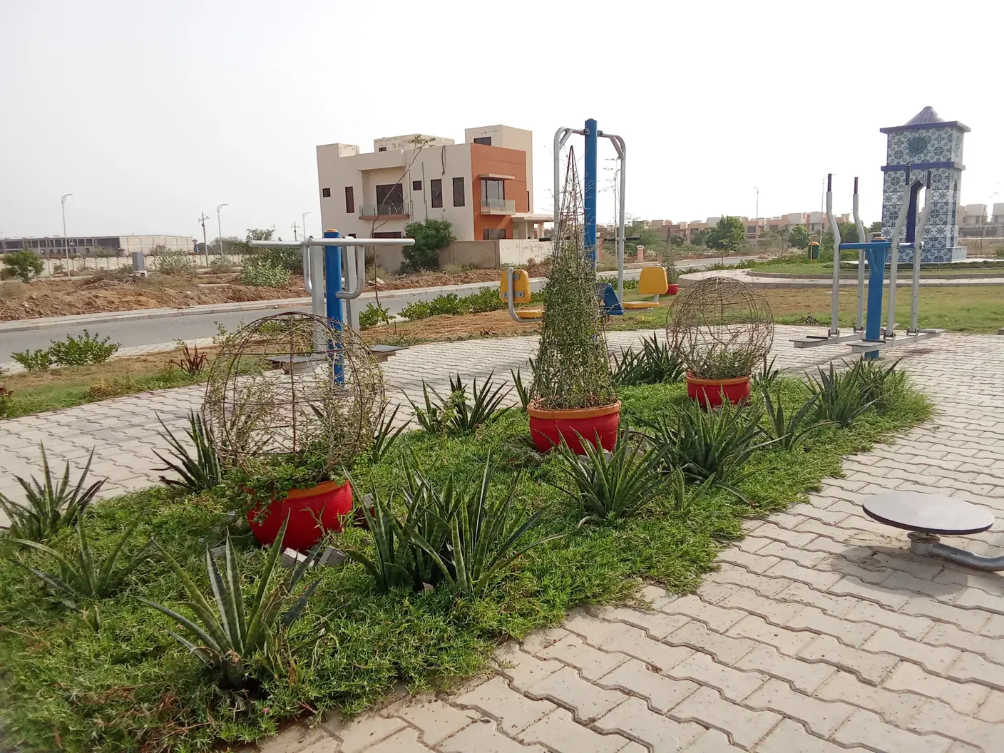 Landscaped garden, villas and tiled clock tower in NHS Mauripur
